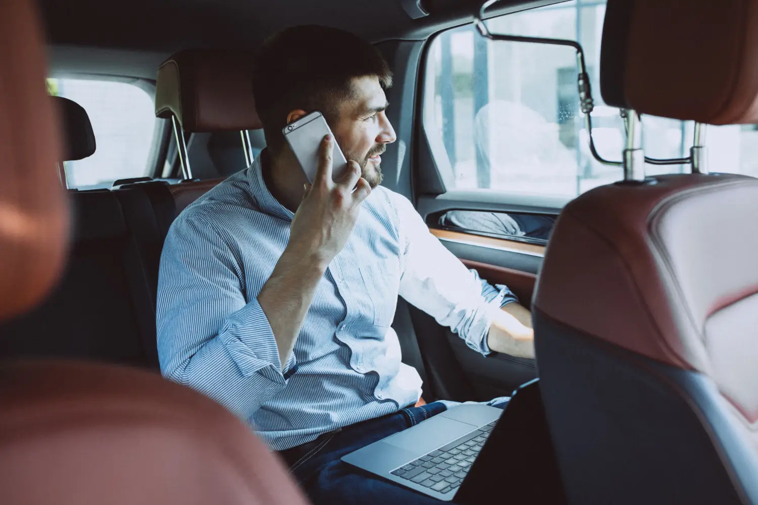 Client d’affaires au téléphone et sur ordinateur portable avec chauffeur privé chris-taxi à blaye