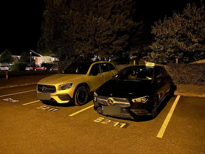 Taxi Mercedes chris-taxi stationné de nuit sur un parking à blaye, à côté d’un SUV haut de gamme