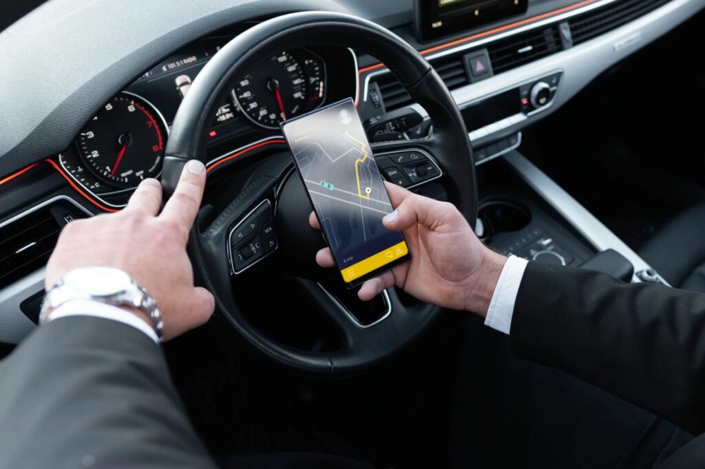 Chauffeur chris-taxi en costume utilisant le GPS au volant d’un véhicule moderne à blaye